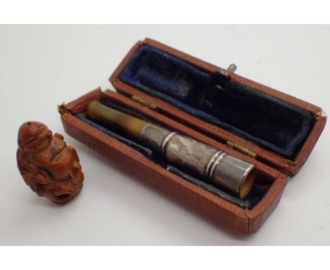 Silver and amber cased cigarette holder and a hand carved netsuke