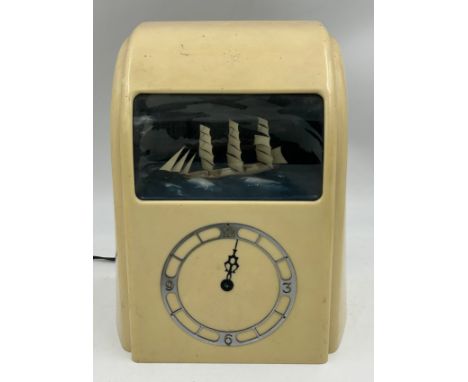A cream Bakelite cased Vitascope automaton mantel clock, 3 masted ship decoration behind perspex window. Original stickers to