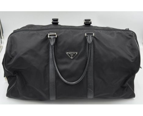 Prada, a black nylon holdall travel bag, with black leather trim and handles, lockable top zip fastening with combination pad