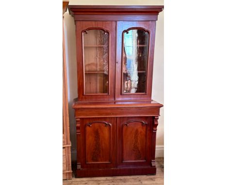 A Victorian mahogany chiffonier bookcase with two arched glazed doors enclosing shelved interior above a drawer and two panel