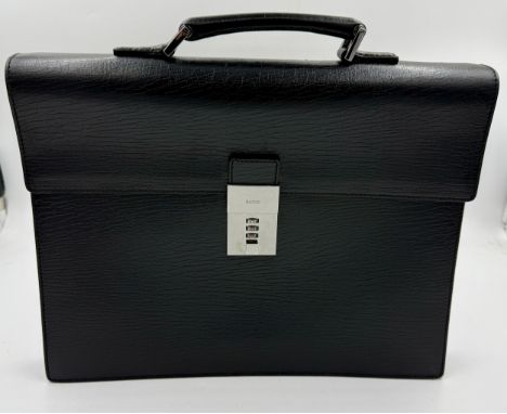 Gucci, a black leather briefcase, with a black loop handle, chrome metalwork and flap with combination lock. Interior with zi