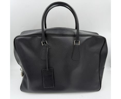 A Prada black leather holdall bag with detachable leather ID tag, lockable top zip fastening with combination padlock and two