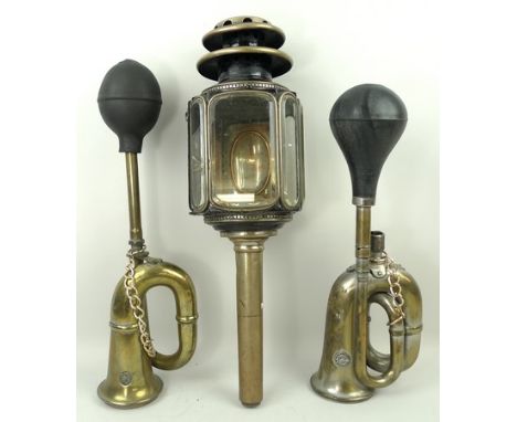A 19th century brass carriage lamp with five panels of bevelled glass, and two early 20th century car horns, a King of the Ro