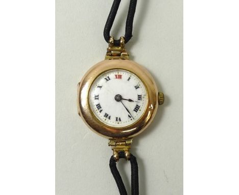 A Rolex lady's 9ct gold circular cased wristwatch, enamel dial bearing Roman numerals, on a black rope strap.