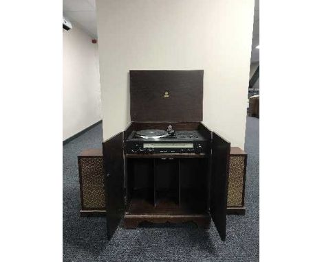 A Dinatrone record player in cabinet and a pair of speakers 