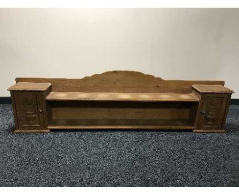 An oak wall shelf fitted with two cupboards and panel doors