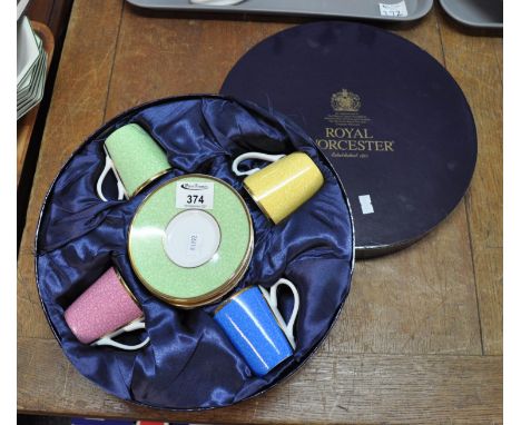 Presentation set of four Royal Worcester coffee cups and saucers, each of a different colour, edged with gilt, in the origina