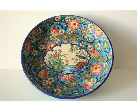 Plat à bord haut sur pied circulaire en faïence émaillée de LONGWY, fond à décor d'oiseaux lacustres, années 50, réhaussé par