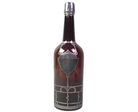 SILVER OVERLAID BROWN GLASS BOTTLE, with initialled shield shaped cartouche29cm high