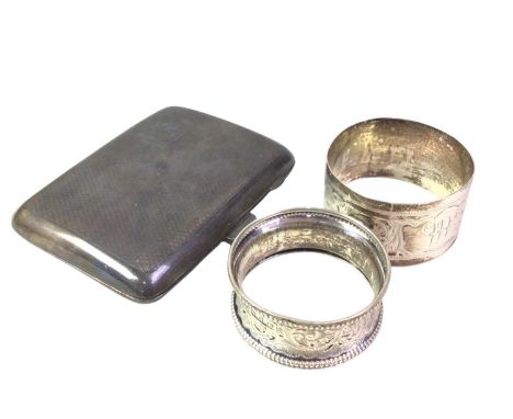 SILVER CIGARETTE CASE, ALONG WITH TWO SILVER NAPKIN RINGS the cigarette case with engine turned decoration and initialled car