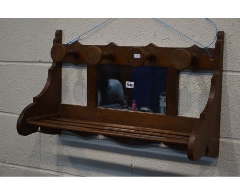 AN EARLY 20TH CENTURY OAK WALL SHELF, with four hooks and central mirror, width 72cm