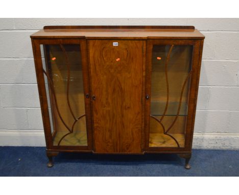 A 1930'S WALNUT SIDE BY SIDE BOOKCASE with a central cupboard door, width 119cm x depth 34cm x height 109cm (missing glazed p