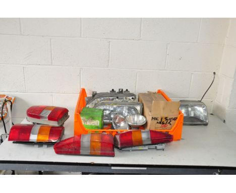 A TRAY CONTAINING VINTAGE CAR HEAD AND TAIL LIGHTS including a brand new old stock SAP Ford Sierra Mk2 NS rear lamp, a pair o