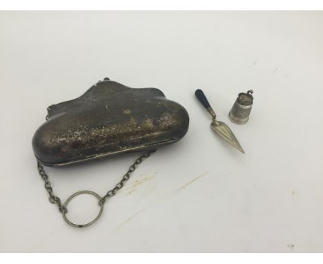 A hallmarked silver miniature trowel money clip; together with a silver-plated purse and thimble