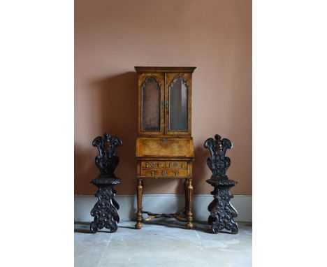 A QUEEN ANNE WALNUT AND FEATHER BANDED BUREAU CABINET CIRCA 1705The mirror panel doors opening to a shelved interior, the fal