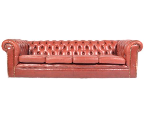A 20th antique vintage Chesterfield four seater sofa settee having oxblood red leather upholstery with deep button back arms 