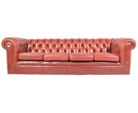 A 20th antique vintage Chesterfield four seater sofa settee having oxblood red leather upholstery with deep button back arms 