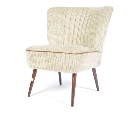 A 20th century German retro vintage shell back cocktail / bedroom chair having a deep sprung seat and ribbed wide backrest up