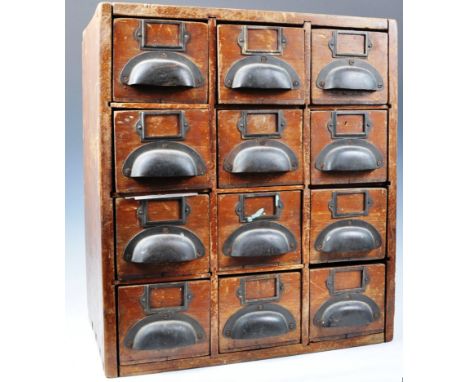 An early to mid 20th century vintage industrial oak counter top twelve drawer index chest having dovetail joints to the exter
