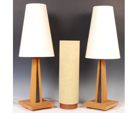 A pair of contemporary oak table lamps having square tapering columns with black and gold flecked design to centre on a plint