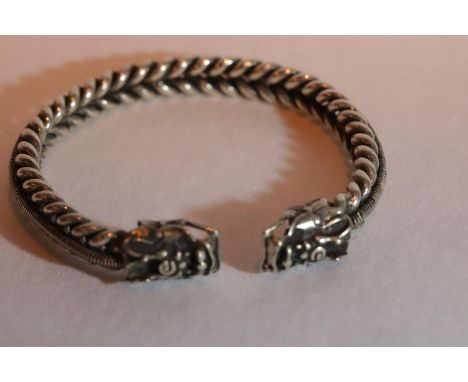 White metal Tibetan silver bangle with dragon head terminals, D: 8 cm. P&amp;P Group 1 (£14+VAT for the first lot and £1+VAT 