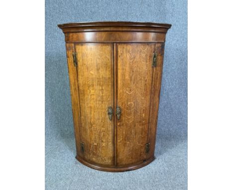 A Georgian oak bow fronted corner cupboard. H.108 W.74 D.51cm 