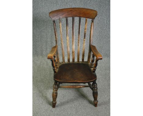 A 19th century elm seated stick back kitchen chair. 