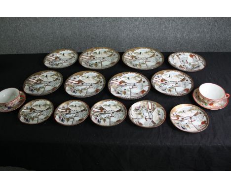 A group of Japanese Satsuma porcelain plates and a pair of tea cups and saucers. Dia.21cm. (largest). 
