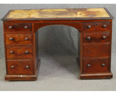 A mid 19th century mahogany pedestal desk with an inset leather top above an arrangement of drawers opposing dummy drawers. (