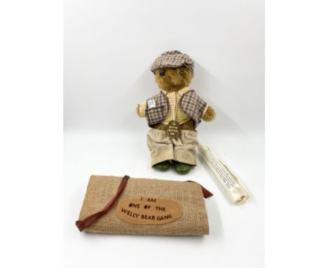 A handmade 'Welly Bear Gang' teddy bear by Laura Grand with a certificate of authenticity and a hessian bag. H.35cm 