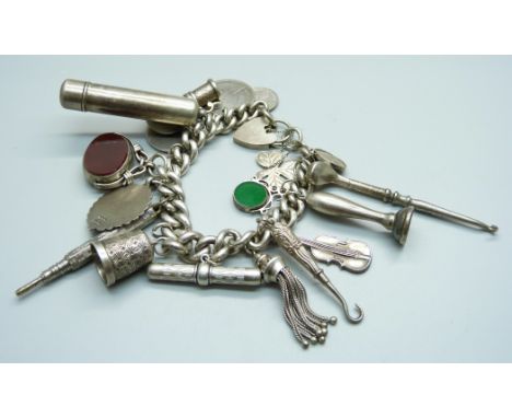 A silver charm bracelet, with Victorian silver swivel fob, a hallmarked Victorian silver violin charm, golf club button hook 