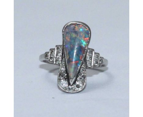 A white metal, opal and diamond ring, the top set with a drop-shaped opal and with diamonds to surround and shoulders. Estima