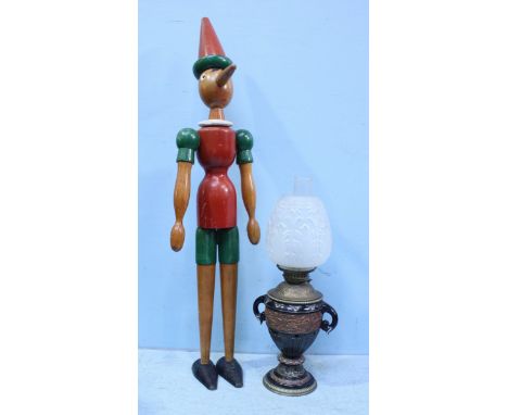 A painted wooden jointed Pinocchio, approximately 108cm high, together with an oil lamp (as found)