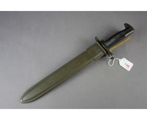 A US M1 Bayonet held within green scabbard. Having plastic grips with all serial numbers and marks removed.