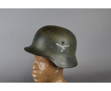A WW2 German M40 helmet, bearing Luftwaffe decals. Leather insert to interior with numbers "0-62" and "T822"