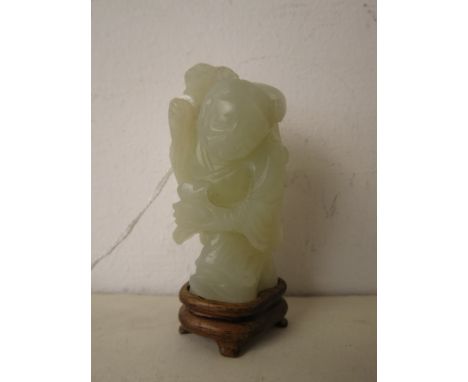 A carved Chinese jade figure of a wise man holding a rat, on a wooden base, 2.5 high