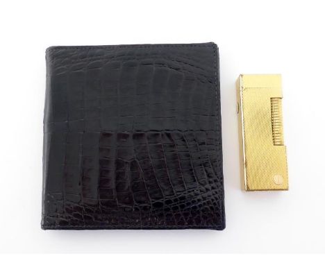 Dunhill, a gold plated lighter, with engine turn design, 6.3cm long, together with a black leather wallet (2) CONDITION: wear