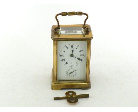 A brass cased carriage clock with bevelled glass side panels, the white dial with Roman numerals and subsidiary alarm dial, s