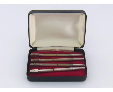 A set of four white metal engine-turned bridge pencils stamped "STERLING SILVER", probably American, each one enamelled to te