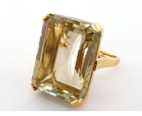 An 18 carat gold and citrine dress ring, the large rectangular step cut stone approx. 37 carats, the shank fully hallmarked, 