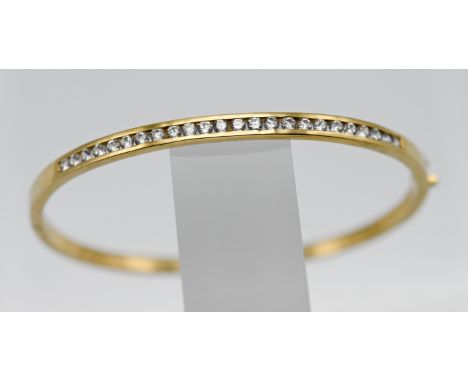 An 18ct yellow gold and diamond half snap channel set bangle, set with twenty four modern brilliant cut diamonds, approx. 19.