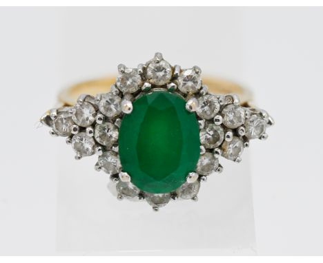 An 18ct yellow gold diamond and emerald cluster ring, size N.