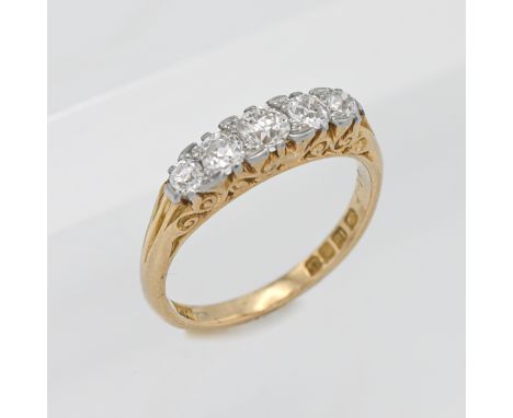 An 18ct yellow gold five stone diamond ring set with old cut diamonds in a scroll head setting, size N/O