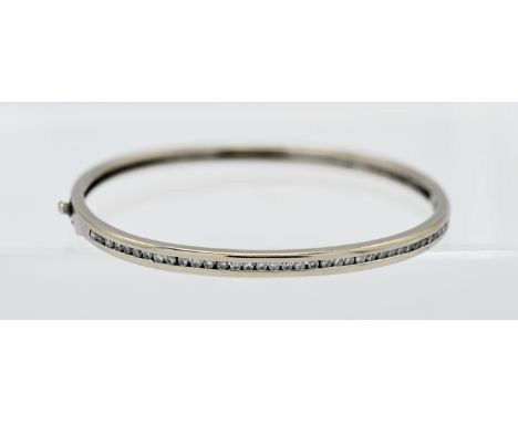 An 18ct white gold and diamond bangle, with copy of receipt from Harvey Nichols dated 2001, purchased at £1,405.00.