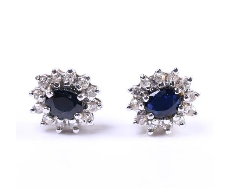 14 carat yellow gold women's entourage ear studs, each set with an oval cut blue sapphire in the center of approx. Diamond qu
