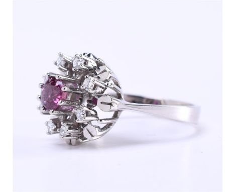 14 carat white gold ladies rosette ring in the shape of a snowflake. The ring is set with a brilliant cut ruby of 0.50 ct. Al