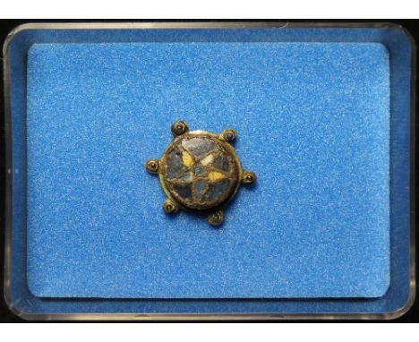 Anglo-Scandinavian enamelled disc brooch with a floral geometric design, consisting of a circular deep blue background with a