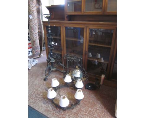A wrought iron and gilt decorated ceiling light, standard lamp, mirror, candle stand and umbrella stand 
