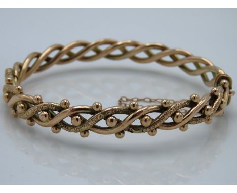 An antique 9ct gold bangle of decorative form with carved decor to top, 60mm diameter internally, 9.5g