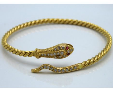 A yellow metal snake bangle, tests electronically as 18ct gold, set with approx. 0.5ct of diamond & rubies for eyes, 24.8g, w